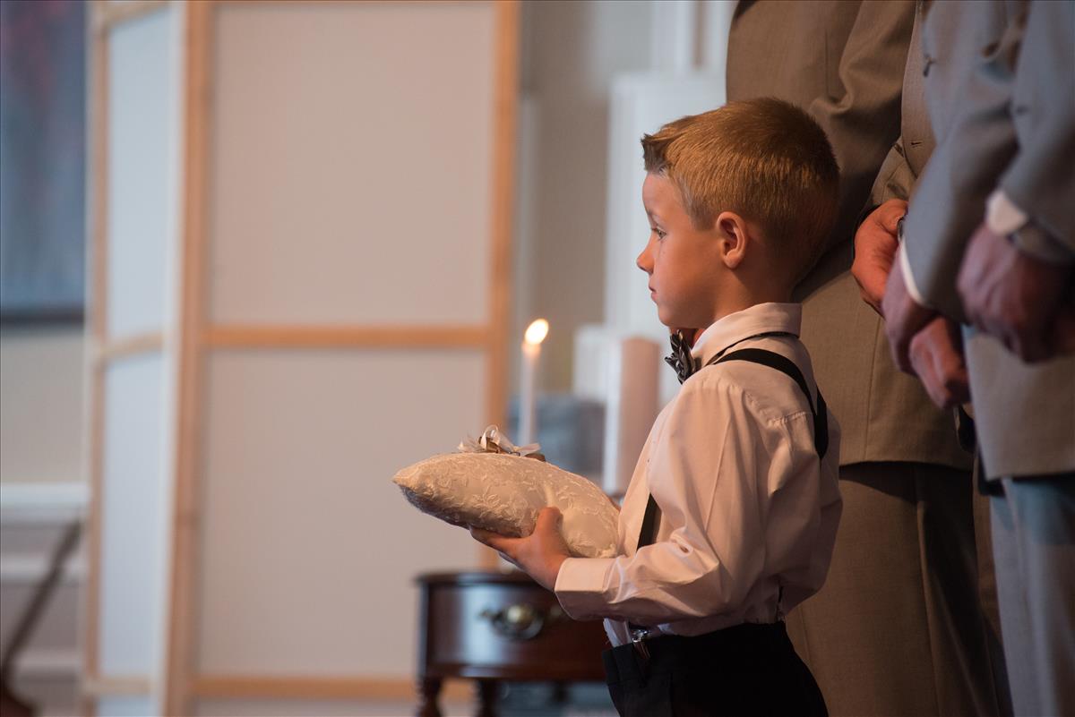 Young ring-bearer waiting his turn at a wedding